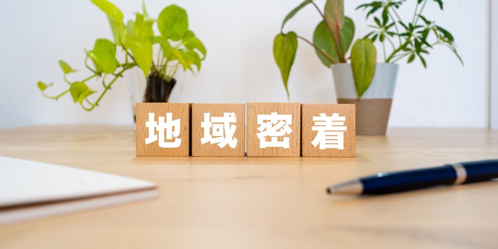 木製ブロックに「地域密着」と書かれたイメージ写真