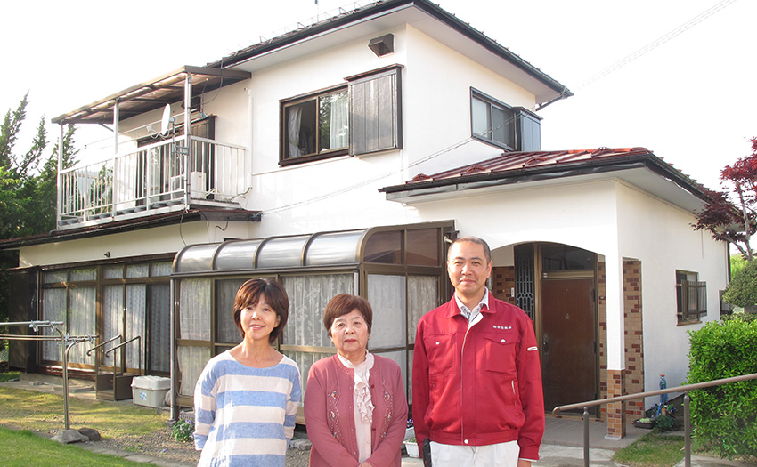 白い外壁の戸建て住宅と家族
