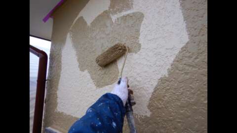 外壁塗装をしている手元