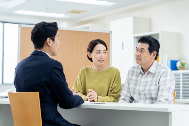 男性営業マンと話す中年夫婦