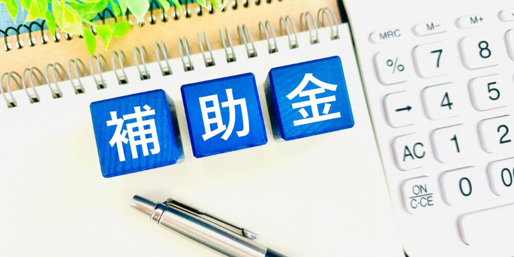 電卓とシルバーのボールペンが置かれている