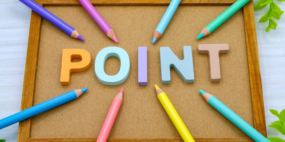 コルクボードの上に、パステル調の立体文字で『POINT』と並び、その周囲をカラフルな色鉛筆が放射状に囲んでいるイメージ